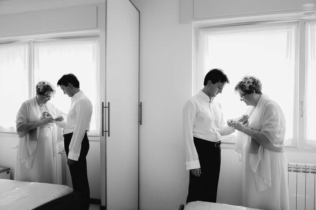 La madre acconcia lo sposo in preparazione della cerimonia