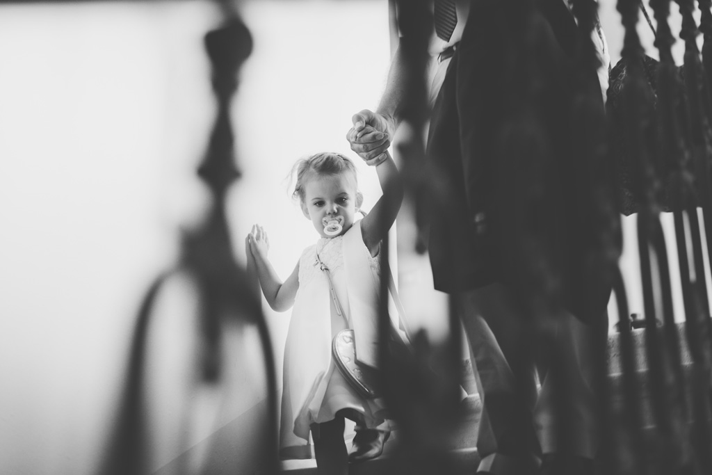 Una bambina scende le scale accompagnata da una damigella