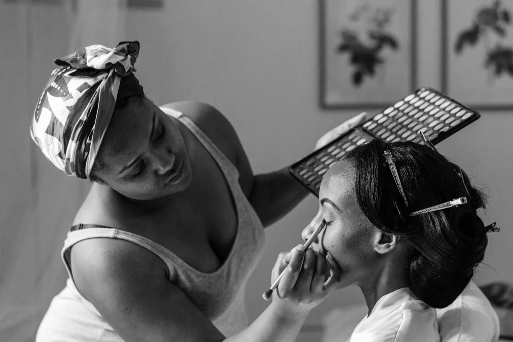 Una damigella decora il viso della sposa