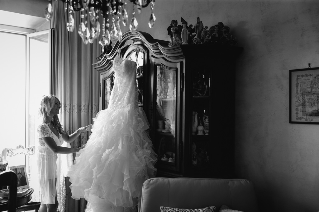 La sposa accarezza il suo abito che indosserà alla cerimonia di matrimonio