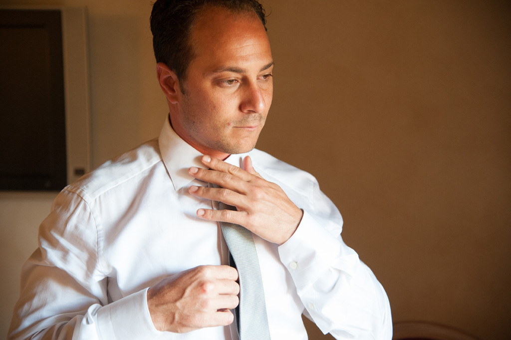 Emmanuel sistema la cravatta sopra la camicia