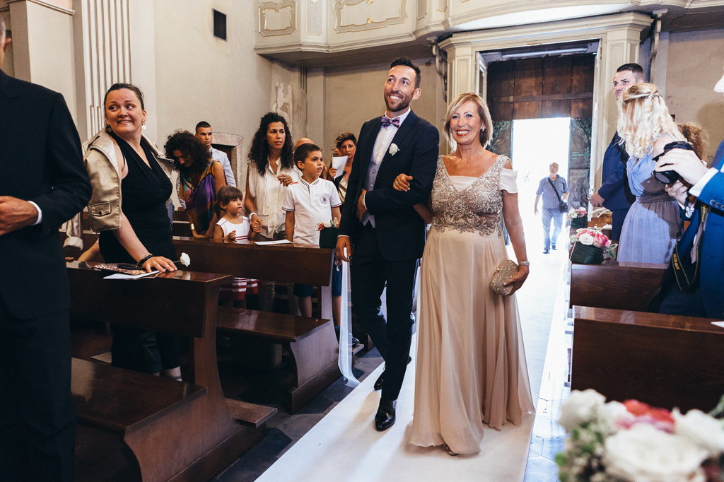 Lo sposo e la madre attraversano la navata della chiesa