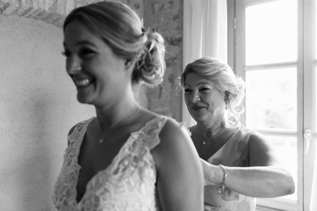La madre della sposa sistema con cura il vestito della figlia Emily