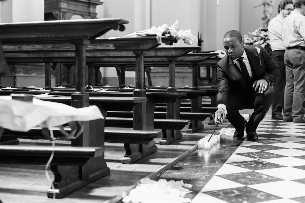 Un invitato accende le candele all'interno della chiesa