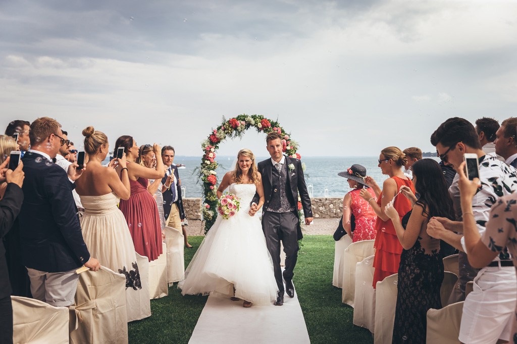 I due sposi attraversano telo bianco a seguito della cerimonia di matrimonio