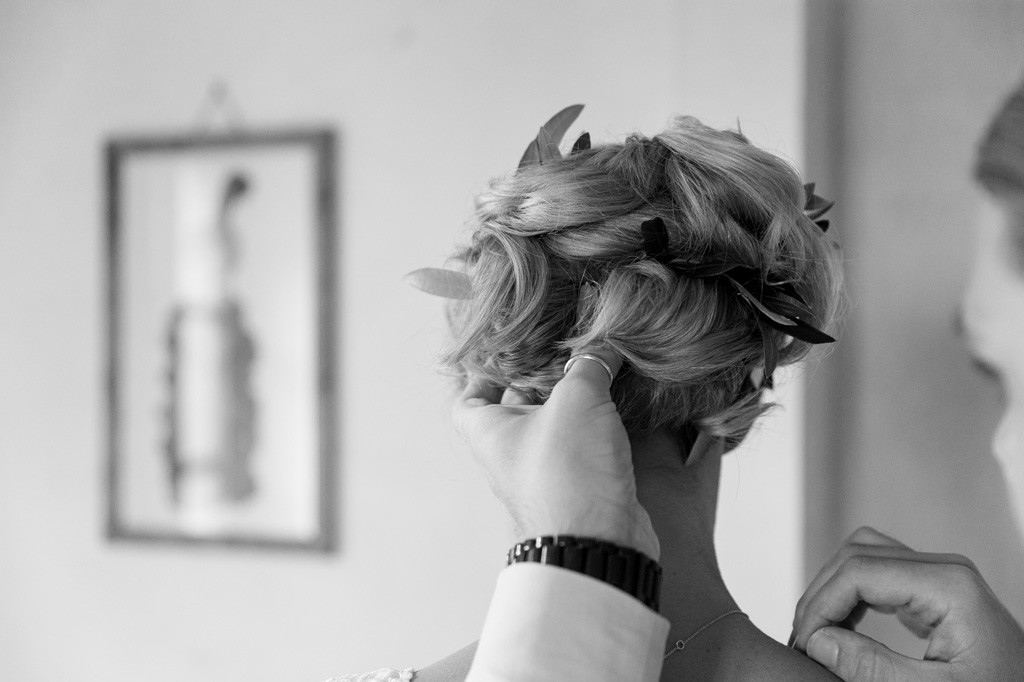Il parrucchiere sistema i capelli della sposa