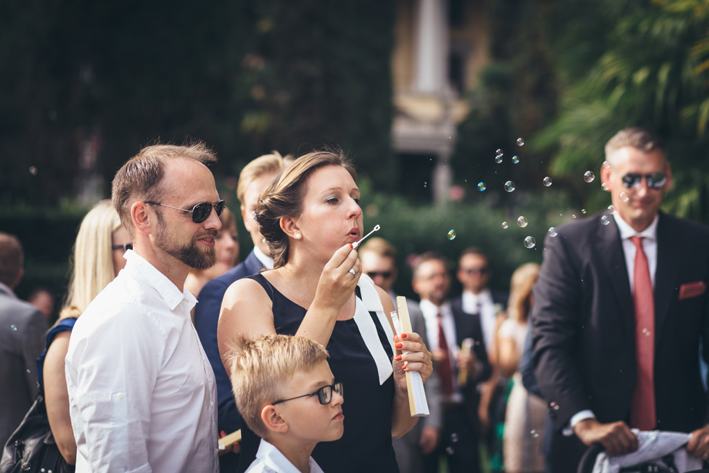 Un'invitata soffia le bolle di sapone in direzione degli sposi