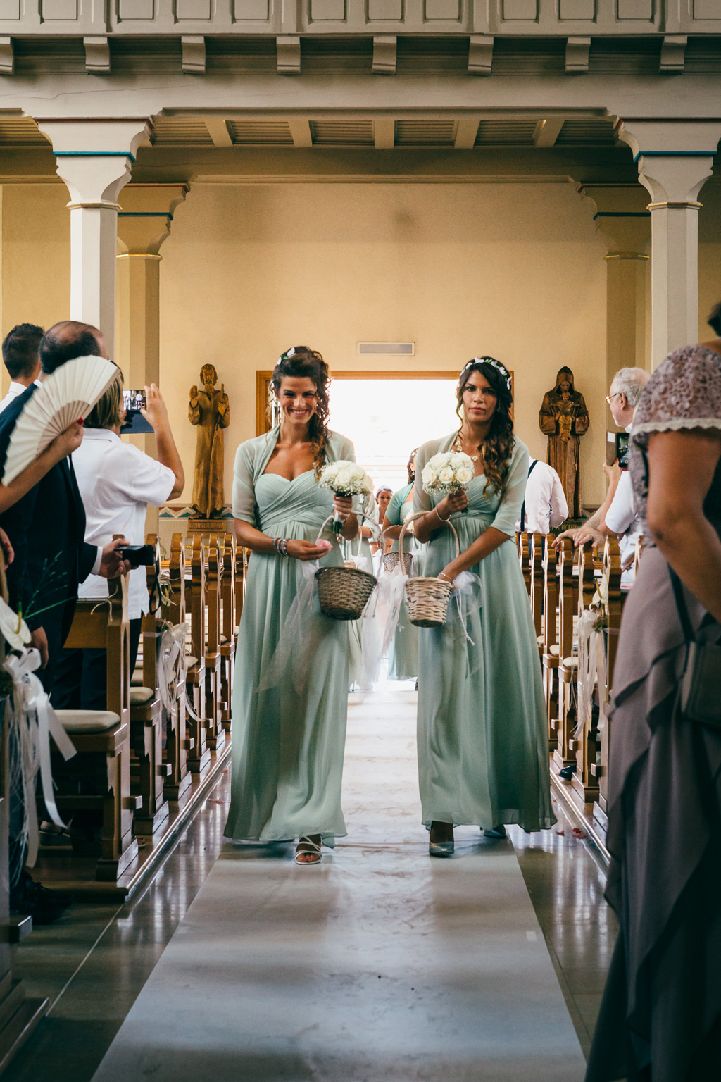 Le damigelle spargono rose sul corridoio della chiesa
