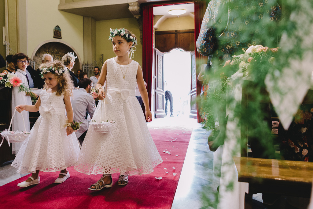Due bambine versano petali lungo il corridoio della chiesa a Sanremo