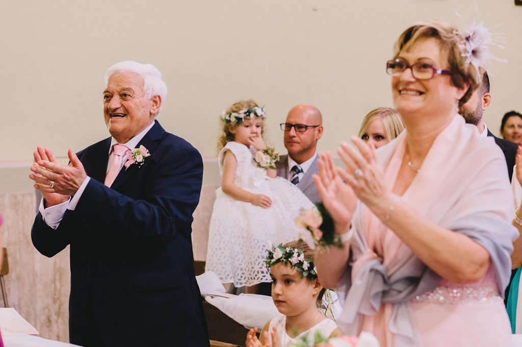 Gli ospiti applaudono fragorosamente gli sposi durante la cerimonia di matrimonio