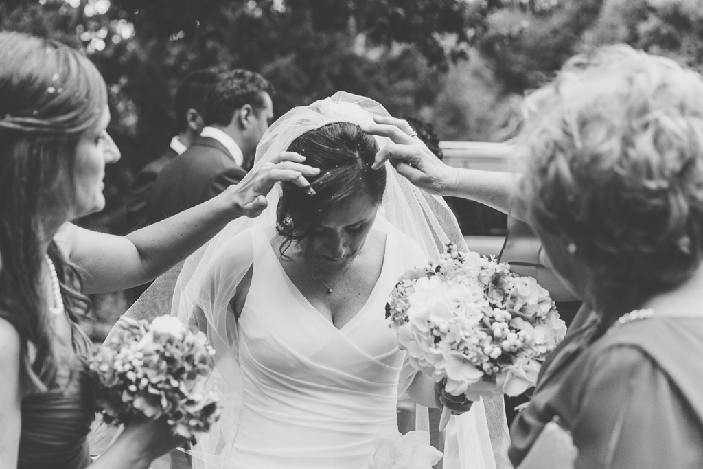 Alcuni parenti sistemano i capelli della sposa ricoperti di riso