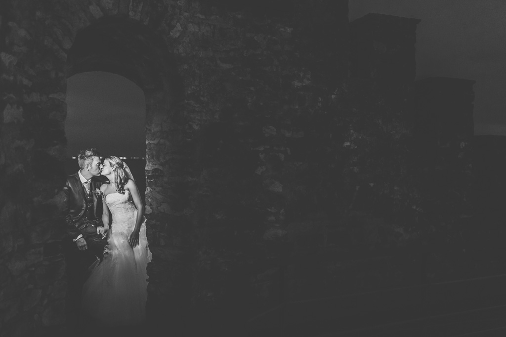 I due sposi si baciano in una atmosfera di un castello diroccato nei pressi del Lago di Garda nella location di Torre San Marco a Brescia