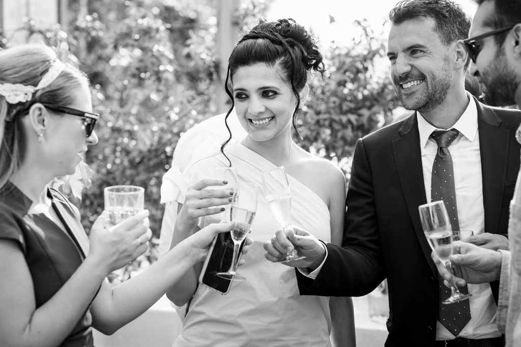 Gli invitati brindano ai nuovi sposi con bicchieri di champagne