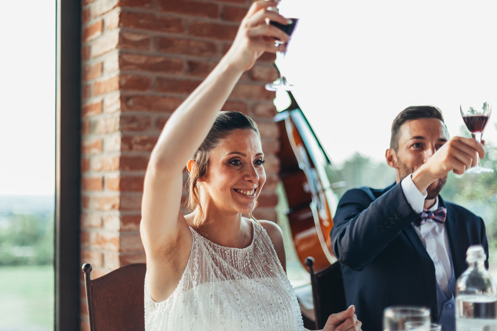 La sposa e lo sposo alzano i bicchieri per festeggiare con gli invitati