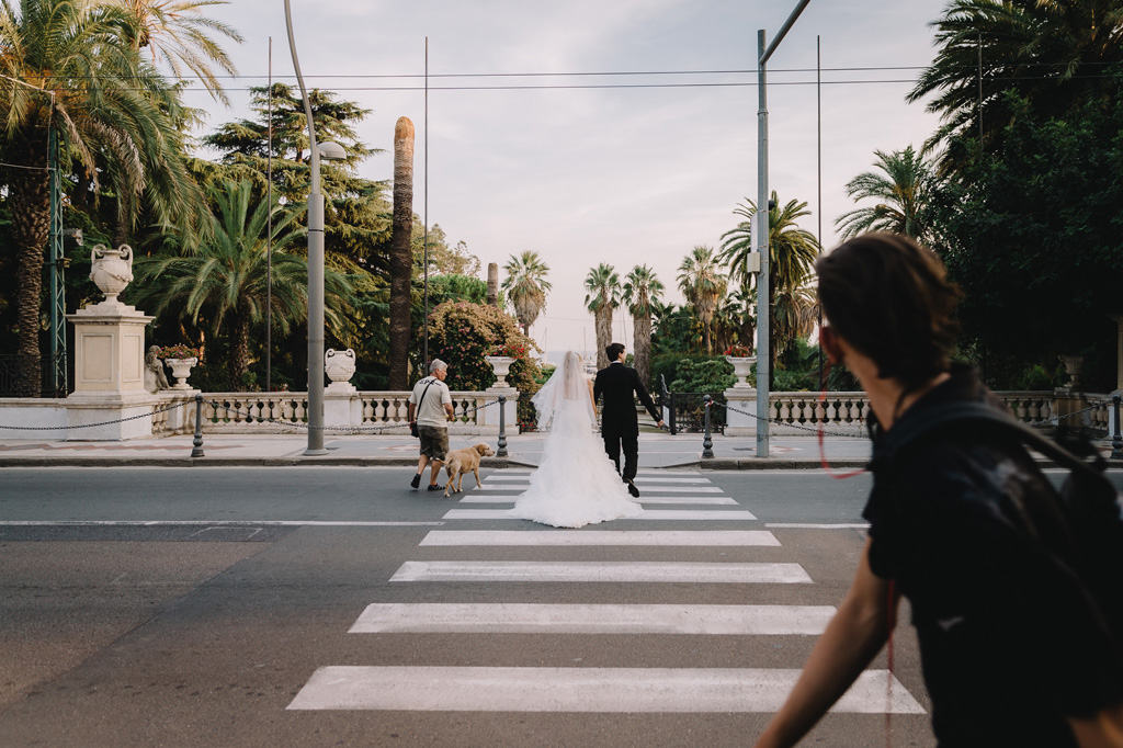 I due sposi attraversano un marciapiede a Sanremo