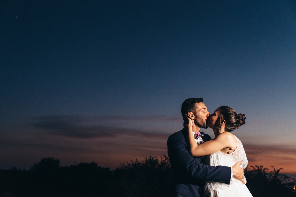 Gli sposi, Fabrizio e Cristina, si scambiano un bacio al tramonto in uno scatto di Della Savia
