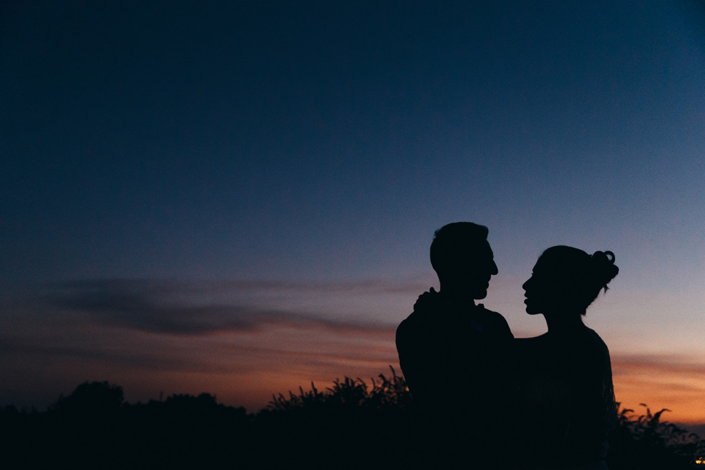 Gli sposi si scambiano un bacio in silhouette
