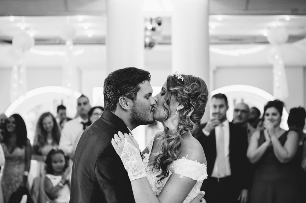 Lo sposo bacia dolcemente la sposa in sala ricevimento