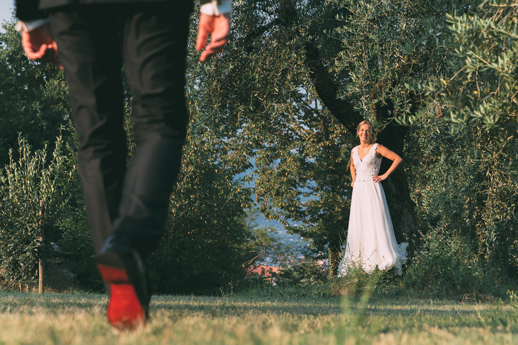 La sposa sorride allo sposo prima di posare nuovamente per il fotografo