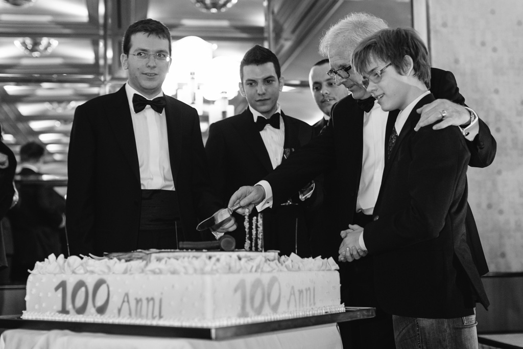 I colleghi s'apprestano a tagliare la torta del centenario dello studio Paltrinieri