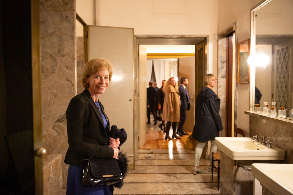 Un'invitata alla cena sorride davanti all'obiettivo del fotografo