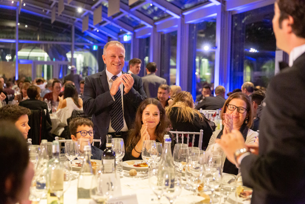 Gli invitati applaudono divertiti l'ospite