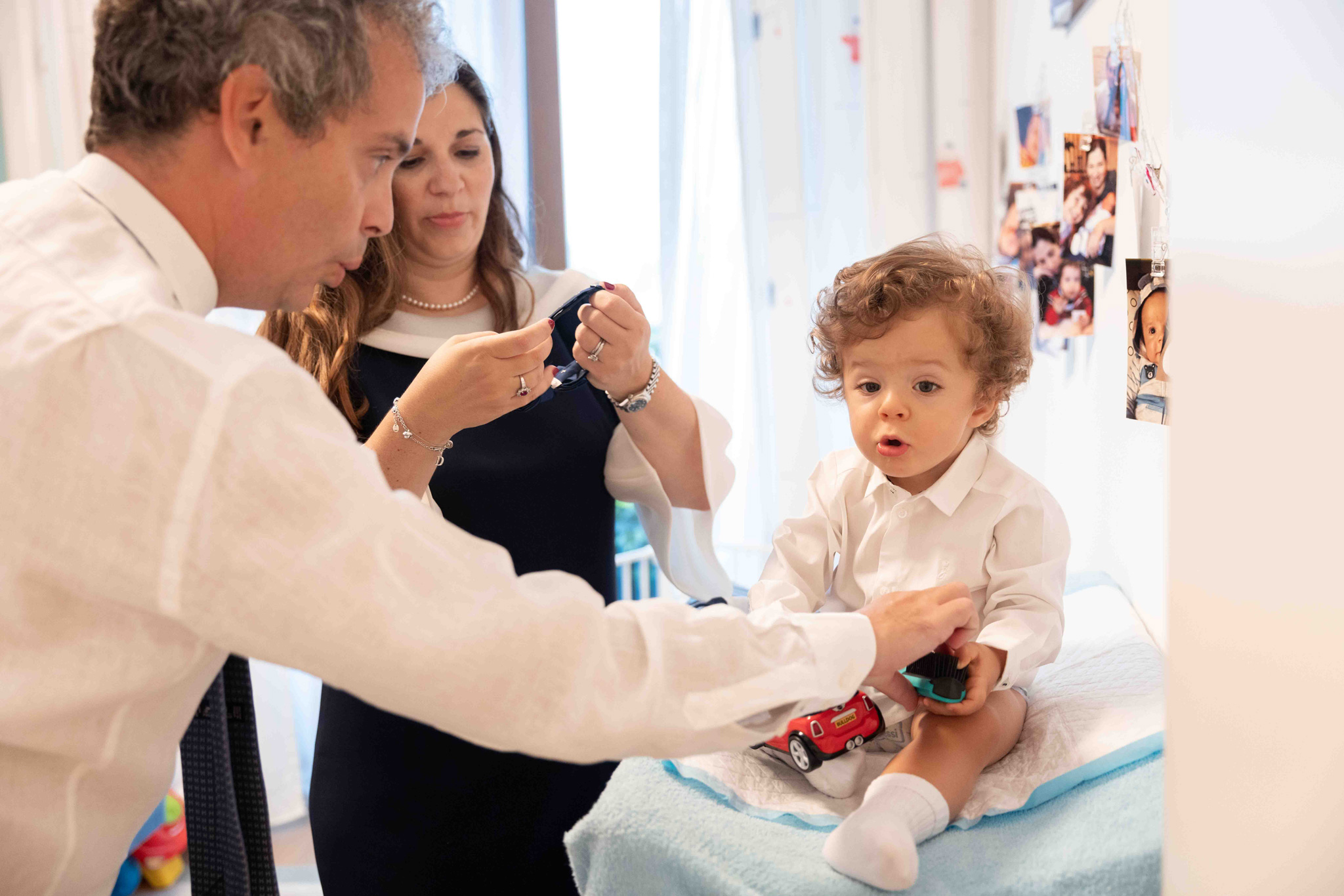 Foto di vestizione bambino con padre e madre battesimo