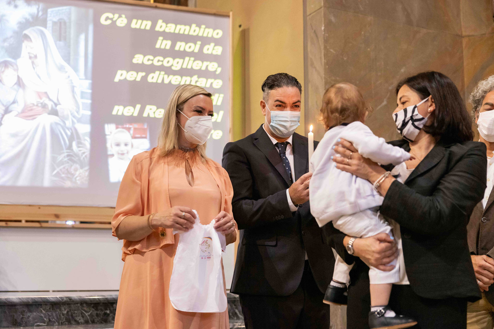Famiglia con bambino dopo battesimo nella parrocchia di comenduno