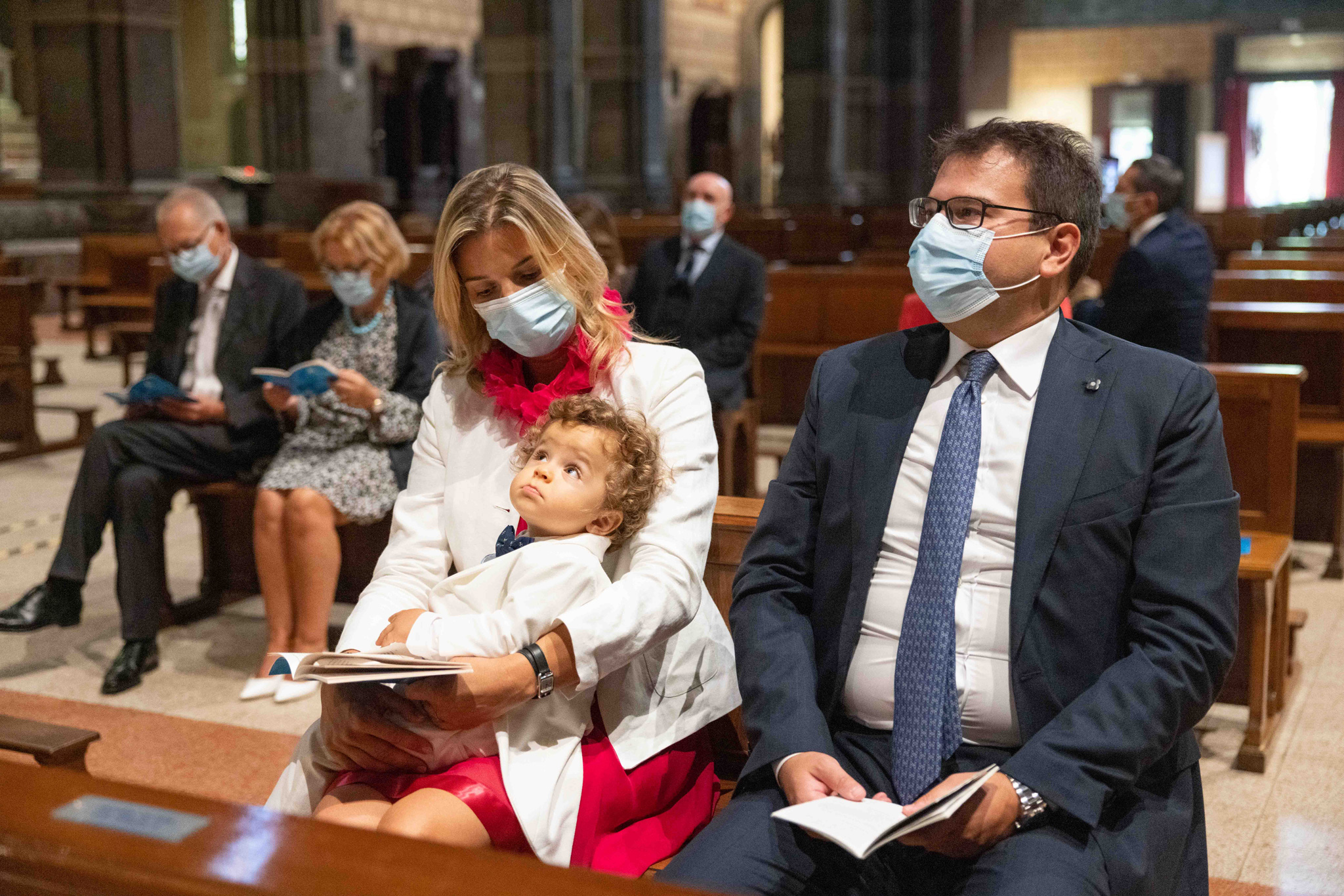 Genitori con bambino il giorno del battesimo a Basilica Parrocchiale Corpus Domini a Milano