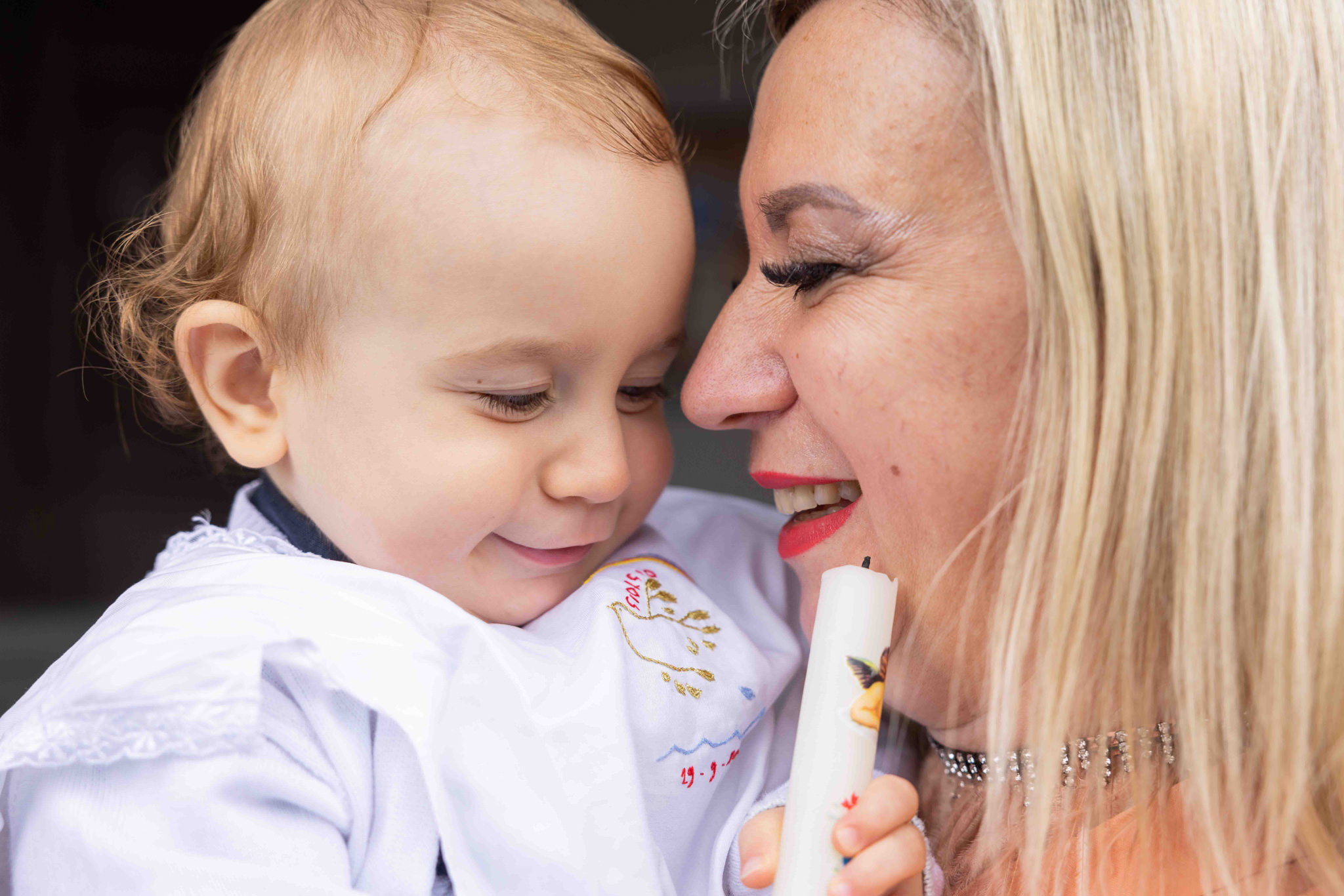 Bambino con madre dopo il battesimo nella parrocchia di Comenduno