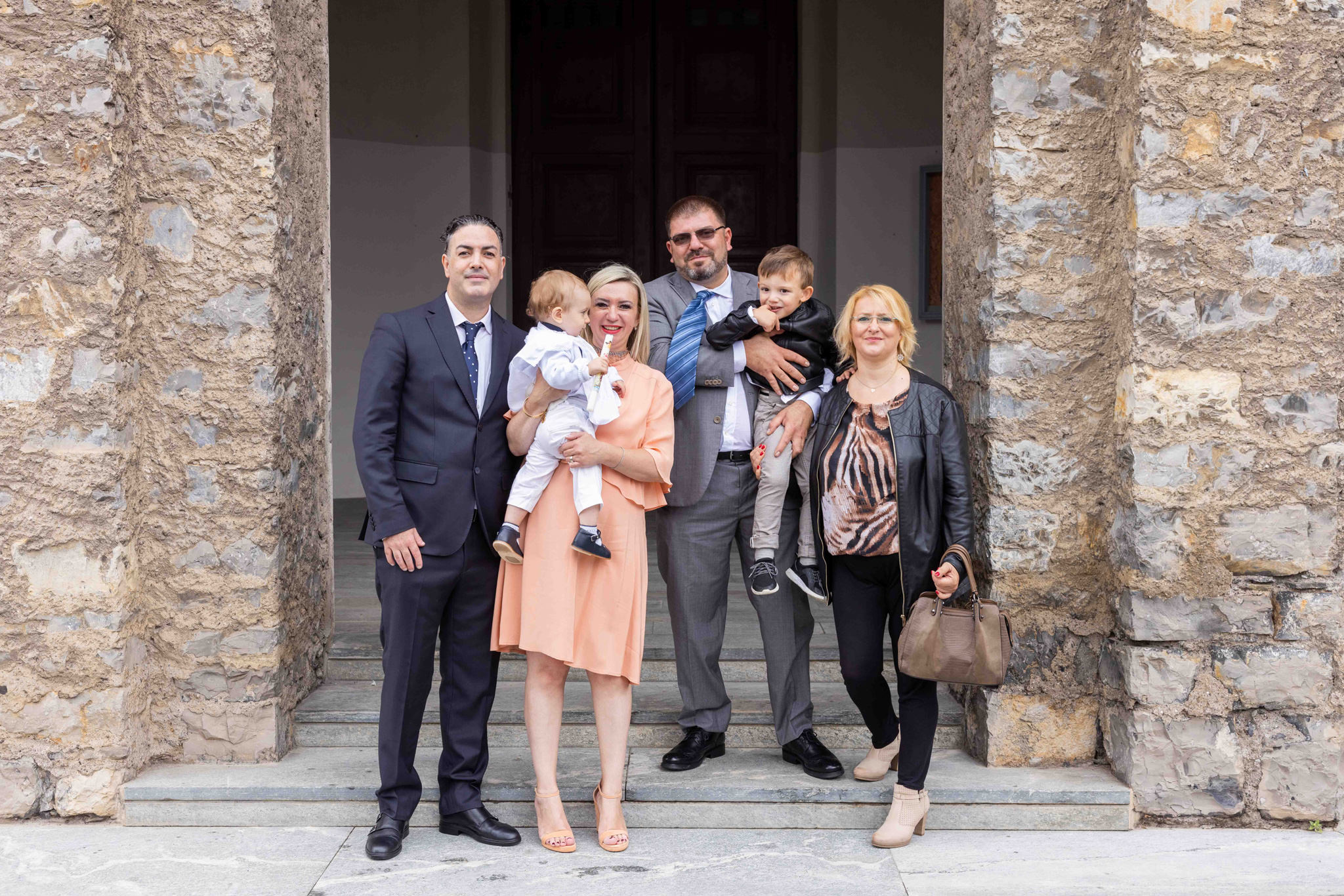 Foto di famiglia dopo il battesimo fuori la parrocchia di comenduno