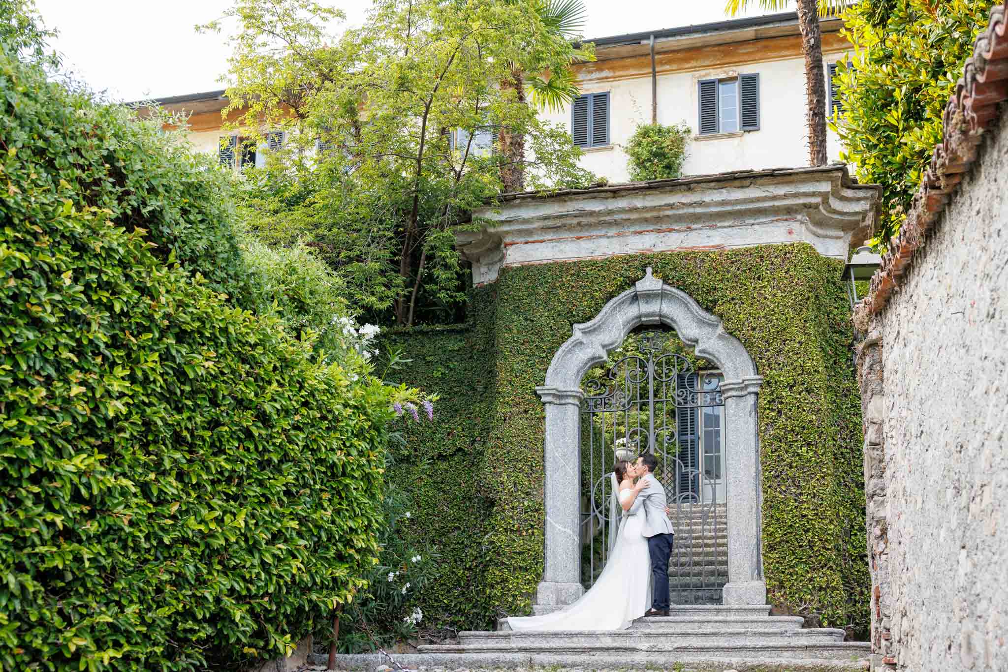 Una coppia di sposi che si baciano alle porte di una villa sul lago di Como