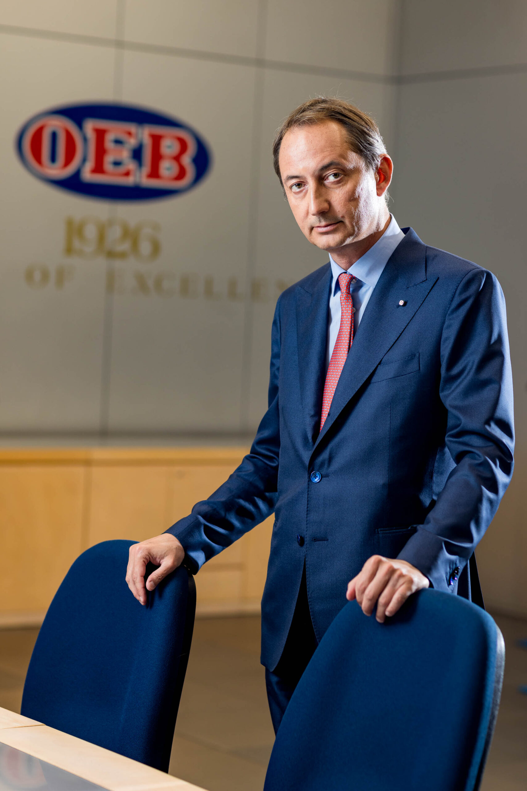 Ritratto business ambientato di un manager nel suo ufficio moderno a Milano, illuminazione naturale e posa professionale